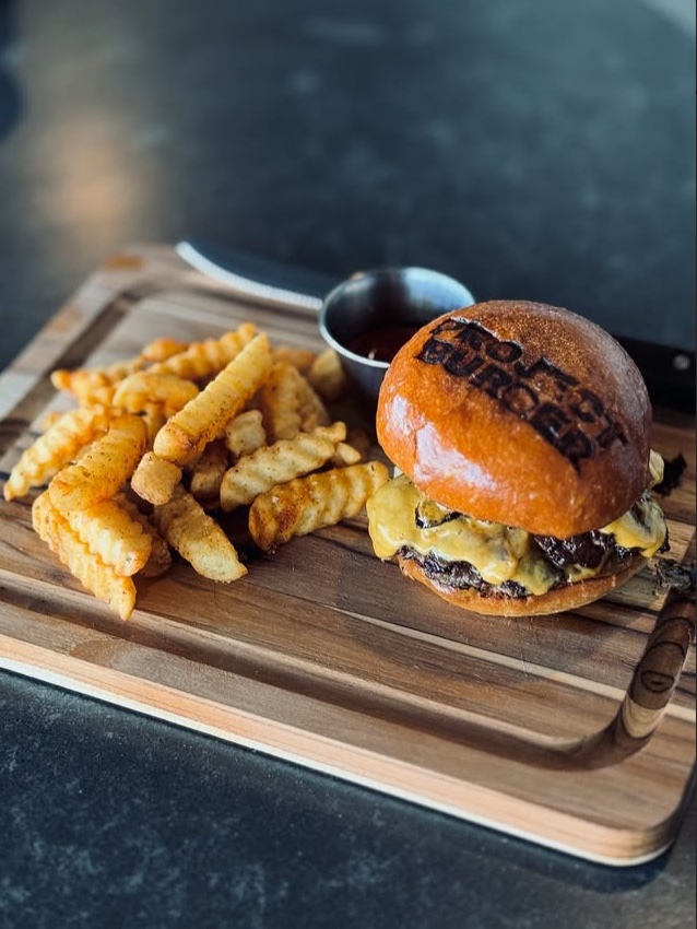 The Project — branded bun with crinkle fries on a wood board