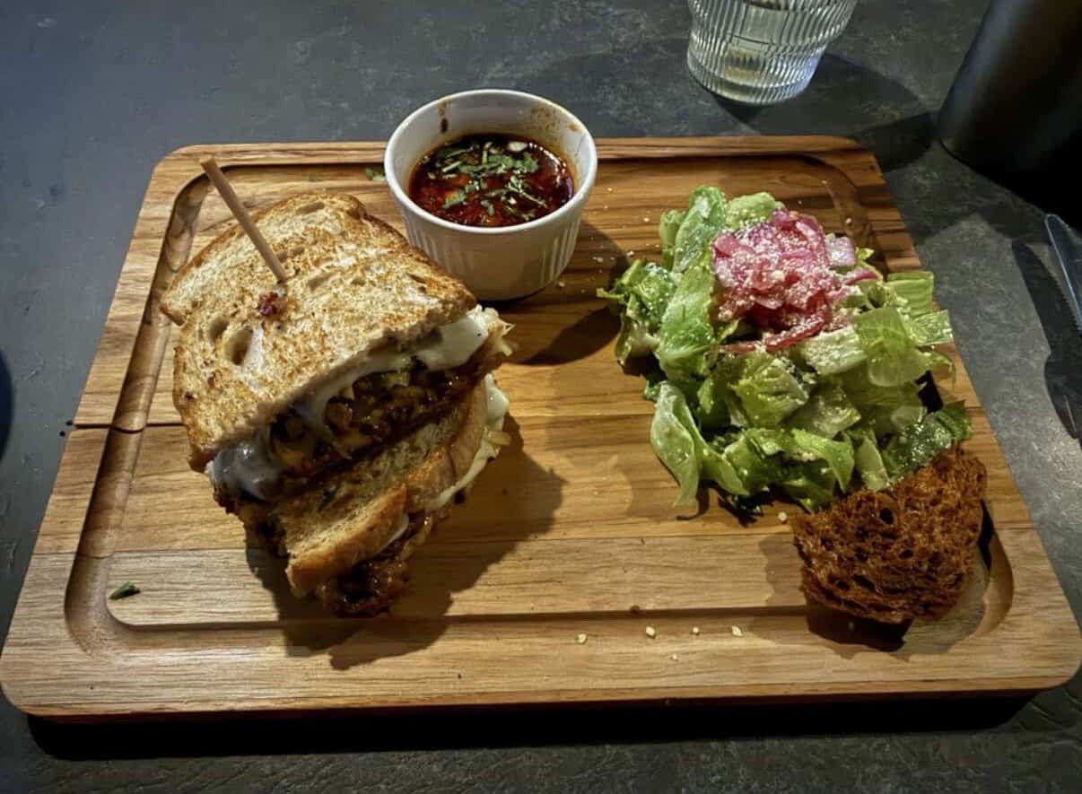 Barbacoa sandwich with consomé and Caesar salad